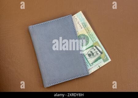 Saudi-Riyal-Währung in einer grauen Brieftasche auf Lederoberfläche. Nahaufnahme. Stockfoto