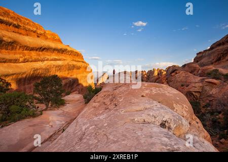 Ein Wanderer steht auf den Klippen des Devils Garden Trail im Arches National Park, Utah Stockfoto