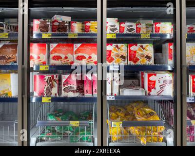 Gefrierbereich in einem Geschäft mit vielen verschiedenen Arten von gefrorenen Kuchen. Kuchen sind in verschiedenen Farben und Geschmacksrichtungen erhältlich. Stockfoto