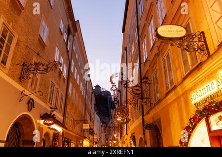 SALZBURG, ÖSTERREICH - 3. FEBRUAR 2024: Berühmte historische Getreidegasse mit mehreren Werbeschildern. Die Salzburger Altstadt wurde zum UNESCO-Weltkulturerbe erklärt Stockfoto