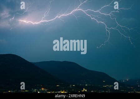 Ein Blitz hoch am Himmel über den italienischen Alpen an einem Sommerabend Stockfoto