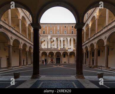 Eleganter Innenhof des Palazzo della Cancelleria, historische Architektur mit hohen Steinsäulen, die anmutige Bögen stützen, Rom, Italien Stockfoto