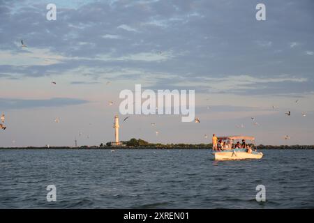 Bootstour mit Möwen, die in der Nähe des Leuchtturms am Schwarzen Meer fliegen, Sulina, Rumänien Stockfoto