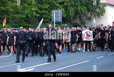 Bautzen, Deutschland. August 2024. Die Teilnehmer einer rechtsgerichteten Demonstration werden von Polizisten begleitet. In Bautzen findet eine Christopher Street Day (CSD)-Parade statt; die Abschlussparty nach der Parade wurde von den Organisatoren wegen möglicher Drohungen von Rechtsextremisten abgesagt. Quelle: Sebastian Willnow/dpa/Alamy Live News Stockfoto