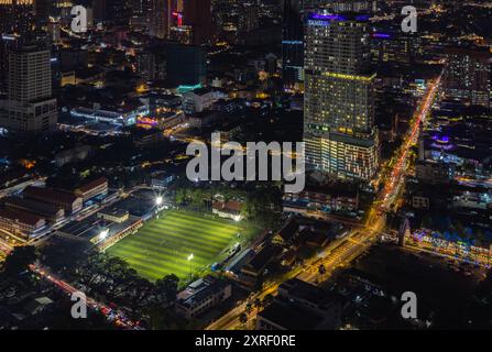 Ein Bild des EV Arena Kelab Sultan Sulaiman Fußballfeldes und des Tamu Hotel and Suites Kuala Lumpur bei Nacht. Stockfoto