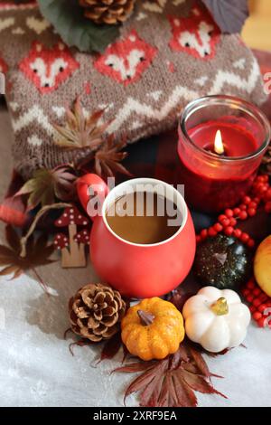Herbstkomposition mit einer Tasse Kaffee, Herbstblättern, roten Beeren, Kürbissen und Strickpullover Stockfoto