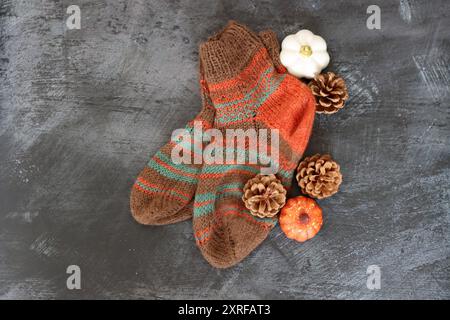 Häkelschläfer auf dunkelgrauem Hintergrund mit Platz für Text. Handgefertigte Strickschuhe aus Wolle. Hobby-Konzept im Herbst. Stockfoto