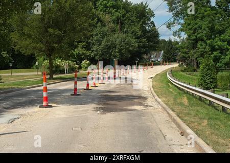 Orangefarbene und weiße Verkehrskegel markieren eine Spur einer Stadtstraße, die wegen Bauarbeiten geschlossen ist Stockfoto