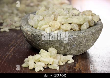 Al-Hojari Boswellia sacra Weihrauchharz aus Oman in einer Steinschale auf Holztisch Stockfoto