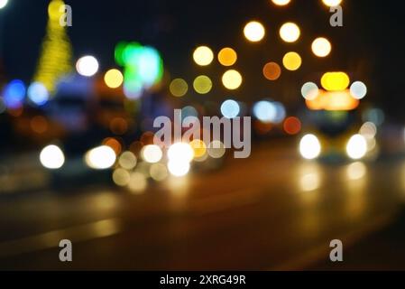 Festliche Atmosphäre von Sarajevo im Dezember: Eine Straße der Stadt bei Nacht, die unscharf fotografiert wurde. Straßenbeleuchtung und Weihnachtsdekoration Stockfoto