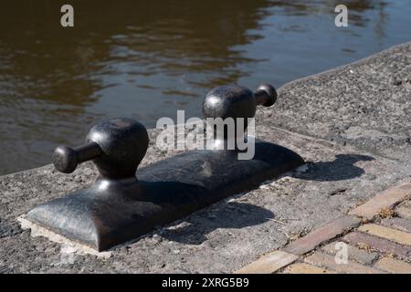 Eisen-Pollerklemme zur Befestigung eines Bootes am Kai, unverzichtbar beim Festmachen, da sie sicherstellt, dass sich das Boot nicht löst Stockfoto