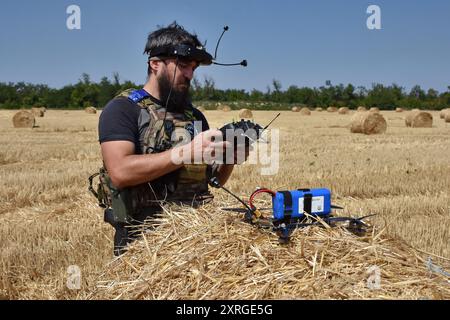 29. Juli 2024, Zaporischschschiha, Ukraine: Ein Drohnenbetreiber der 15. Brigade (Kara-Dag) der Nationalgarde der Ukraine bereitet eine Kamikaze-Drohne für den Flug während einer militärischen Übung vor. Der massenhafte Einsatz von Drohnen der FPV (First-Person-Ansicht) in Feindseligkeiten zwischen ukrainischen und russischen Streitkräften hat das Muster des modernen Krieges radikal verändert. Der erfolgreiche Einsatz einer oder mehrerer billiger Drohnen ermöglicht die Zerstörung von Geräten im Wert von Millionen Dollar. Das Militär verwendet FPV-Drohnen als Kamikaze-Drohnen und installiert verschiedene Sprengköpfe auf ihnen. Auf der anderen Seite FPV Kamikaze dro Stockfoto