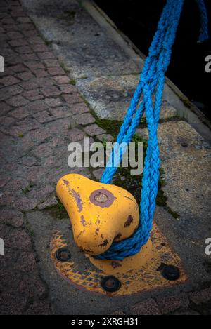 Gelb-Dock-Anlegestange aus Metall mit Seil zur Sicherung von Fischerbooten Stockfoto