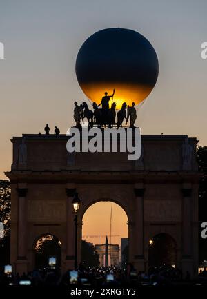 Paris, Frankreich - 08 05 2024: Olympische Spiele Paris 2024. Blick auf den Olympischen Kessel hinter dem Triumphbogen am Carrousel du Louvre bei Nacht Stockfoto