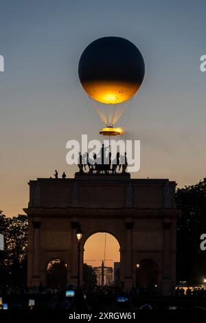 Paris, Frankreich - 08 05 2024: Olympische Spiele Paris 2024. Blick auf den Olympischen Kessel hinter dem Triumphbogen am Carrousel du Louvre bei Nacht Stockfoto