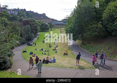 Royal Mile, Edinburgh, Schottland, Großbritannien. August 2024. Ende der ersten Woche rund um die geschäftige High Street und das Stadtzentrum an einem weiteren stürmischen, windigen Samstag mit einer Windgeschwindigkeit von 35 km/h im Bild: Die Leute entspannen sich in den Gärten der Princes Street östlich. Quelle: Arch White/Alamy Live News. Stockfoto