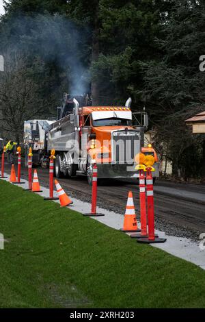 KIRKLAND, WA – 31. JAN 2024: Straßenbaupersonal arbeitet an einer Wohnstraße, fräst Maschinen ab, entfernt alten Asphalt und versorgt ihn Stockfoto