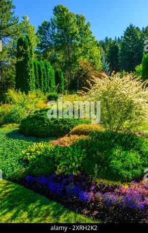 Ein wunderschön gestalteter Garten mit einer Fülle von Blumen und farbenfrohen Pflanzen Stockfoto