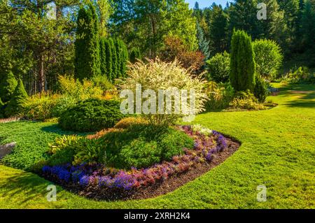 Ein wunderschön gestalteter Garten mit einer Fülle von Blumen und farbenfrohen Pflanzen Stockfoto