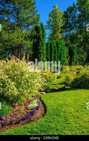 Ein wunderschön gestalteter Garten mit einer Fülle von Blumen und farbenfrohen Pflanzen Stockfoto