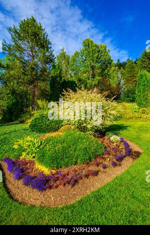 Ein wunderschön gestalteter Garten mit einer Fülle von Blumen und farbenfrohen Pflanzen Stockfoto