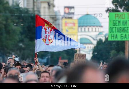 Belgrad, Serbien. August 2024. Ein Demonstrant schwenkt die serbische Flagge mit dem Tempel der Heiligen Sava im Hintergrund während eines Bürgerprotests gegen die anglo-australische internationale Metall- und Bergbaugesellschaft Rio Tinto in Serbien am 10. August 2024 auf dem Terazije-Platz in Belgrad. (Foto: Dimitrije Vasiljevic/Alamy Live News) Stockfoto