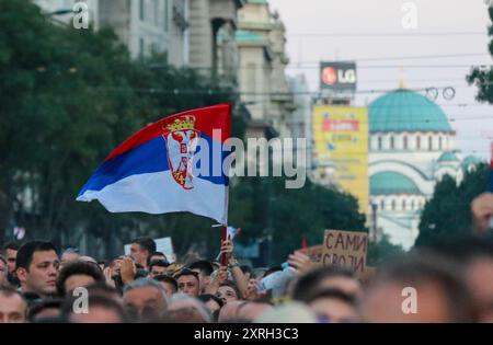 Belgrad, Serbien. August 2024. Ein Demonstrant schwenkt die serbische Flagge mit dem Tempel der Heiligen Sava im Hintergrund während eines Bürgerprotests gegen die anglo-australische internationale Metall- und Bergbaugesellschaft Rio Tinto in Serbien am 10. August 2024 auf dem Terazije-Platz in Belgrad. (Foto: Dimitrije Vasiljevic/Alamy Live News) Stockfoto