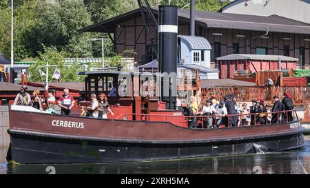 Henrichenburg, Waltrop, Deutschland. August 2024. Cerberus führt Festivalbesucher entlang des Kanals. Steampunk-Fans, Gruppen und Besucher, viele davon in Retro-futuristischen oder viktorianischen Kostümen, haben am ersten Tag des jährlichen Steampunk Jubilee Festivals und Markts Spaß. In diesem Jahr fällt das Festival mit dem 125-jährigen Jubiläum der historischen Henrichenburger Bootsliftanlage zusammen, einem denkmalgeschützten Industriedenkmal entlang des Dortmund-Ems-Kanals. Quelle: Imageplotter/Alamy Live News Stockfoto