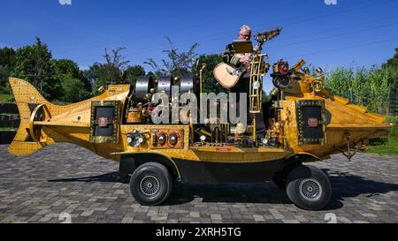 Henrichenburg, Waltrop, Deutschland. August 2024. Die Nautilus One man Band, ein musikalisches U-Boot mit Feuerkraft. Steampunk-Fans, Gruppen und Besucher, viele davon in Retro-futuristischen oder viktorianischen Kostümen, haben am ersten Tag des jährlichen Steampunk Jubilee Festivals und Markts Spaß. In diesem Jahr fällt das Festival mit dem 125-jährigen Jubiläum der historischen Henrichenburger Bootsliftanlage zusammen, einem denkmalgeschützten Industriedenkmal entlang des Dortmund-Ems-Kanals. Quelle: Imageplotter/Alamy Live News Stockfoto