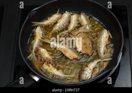 Kleiner Fisch, der in Öl in einer Pfanne frittiert Stockfoto