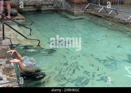 St. Winefrids-Schrein und heiliger Brunnen. Katholische Wallfahrt am 22. Juni zum Festtag des Heiligen Winefride. Im äußeren Becken kniet eine junge Frau auf einem untergetauchten Stein, der als St. Beuno-Stein bekannt ist, so lange es dauert, das Rosenkranzgebet zu vollenden. Ich bin dreimal um den äußeren Pool gelaufen, in der Hoffnung auf ein Wundermittel. Holywell, Flintshire Wales, UK 1990s. HOMER SYKES Stockfoto