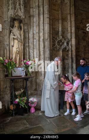 St. Winefrids-Schrein und heiliger Brunnen. Holywell Flintshire. Katholische Pilger am Festtag von Saint Winefride verehren St. Winefride Relic. Ein Vater und seine drei Kinder küssen seine Tochter St. Winefrides Relic. Wales Juni 2023. HOMER SYKES AUS DEN 2000ER JAHREN Stockfoto