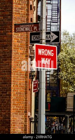 Schild mit der Bezeichnung Christopher Street Stonewall Place sowie Einweg- und Wrong-Way-Schilder, Greenwich Village, New York City, New York, Vereinigte Staaten Stockfoto