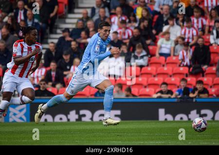 Stoke auf Trent, Großbritannien. August 2024. Der Coventry City-Verteidiger Luis Binks (2) wird am 10. August 2024 von Stoke City Stürmer Niall Ennis (14) während des SKY Bet EFL Championship Matches Stoke City FC gegen Coventry City FC im Bet365 Stadium, Stoke-on-Trent, England, Großbritannien unter Druck gesetzt Stockfoto