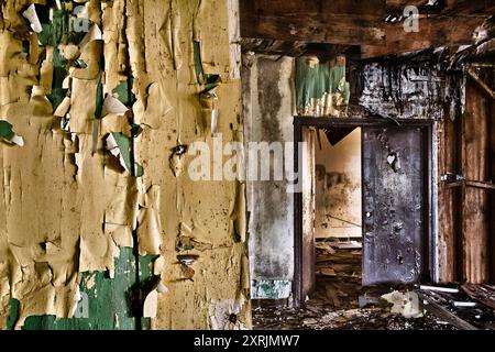 Abblätternde Farbe, bröckelnde Wände und ein teilweise eingestürztes Dach heben den Innenraum der verlassenen Marinestützung Mare Island hervor. Stockfoto