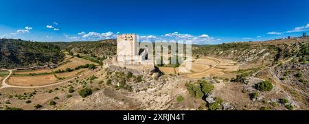 Blick aus der Vogelperspektive auf das spanische mittelalterliche Schloss Paracuellos de la Vega, das auf einem Felsen in Cuenca thront, quadratischer Turm umgeben von einer Ringmauer mit kleinem Kreis Stockfoto