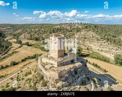 Blick aus der Vogelperspektive auf das spanische mittelalterliche Schloss Paracuellos de la Vega, das auf einem Felsen in Cuenca thront, quadratischer Turm umgeben von einer Ringmauer mit kleinem Kreis Stockfoto