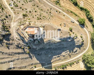 Blick aus der Vogelperspektive auf das spanische mittelalterliche Schloss Paracuellos de la Vega, das auf einem Felsen in Cuenca thront, quadratischer Turm umgeben von einer Ringmauer mit kleinem Kreis Stockfoto