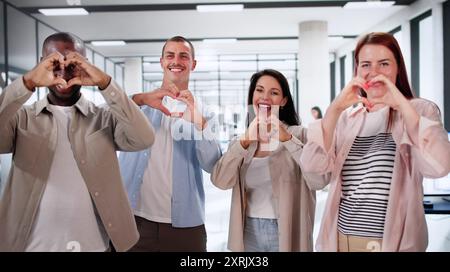 Glückliche Unternehmensmitarbeiter, Die Herzen Mit Händen Machen. Community Am Arbeitsplatz Stockfoto