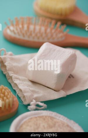 Ein Seifenstab wird auf ein Tuch neben eine Bürste in der Nähe eines Tisches gelegt Stockfoto