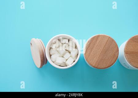 Elegante und stilvolle Behälter mit Zuckerwürfeln auf einem wunderschönen türkisfarbenen Hintergrund Stockfoto