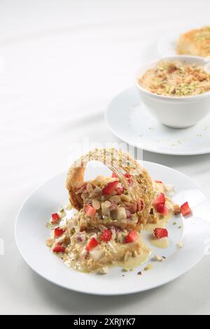 Othmaliye Bil-Kishta und Erdbeerrezept. Beliebte Arabische Süße Othmaliye Bil - Kishta - Crunchy Outside Mit Cremefüllung - Aus Der Kunafa Familie Stockfoto