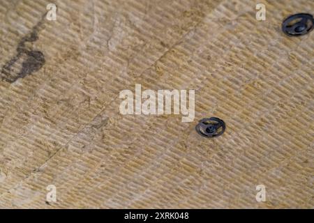 Dämmplatten aus Mineralwolle, die an der Decke verklebt wurden. Stockfoto