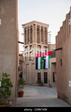 Enge Gasse mit Emiratenflaggen, einer der ältesten Gegenden Dubais im historischen Viertel Al Fahidi Stockfoto