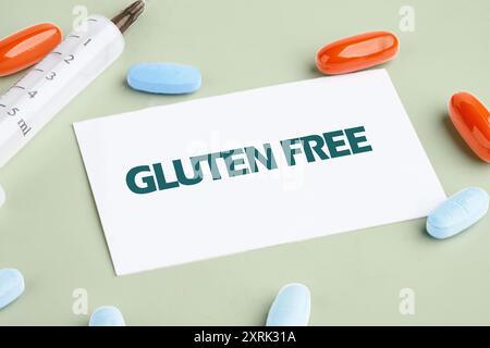 Glutenfreies Backkonzept. GLUTENFREIES Wort auf einer weißen Visitenkarte mit einer Spritze und Tabletten daneben Stockfoto