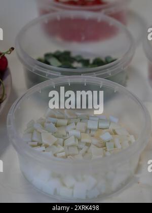 Vertikale Nahaufnahme weißer, grüner und roter Vitrage-Glasstücke in Kunststoffbehältern. Stockfoto