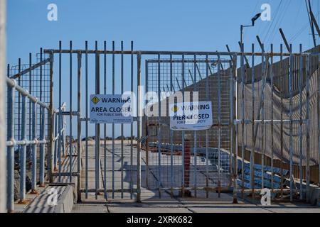 Verschlossenes rostendes Metalltor am Middle Brighton Pier mit Warnschild Parks Victoria, das besagt, dass der Pier aus Gründen der öffentlichen Sicherheit geschlossen ist Stockfoto