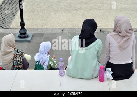 West-Java, Indonesien - 11. August 2024 : vier Frauen mit Hijabs sitzen in einem Stadtpark in Tasikmalaya, West-Java, Indonesien. Stockfoto