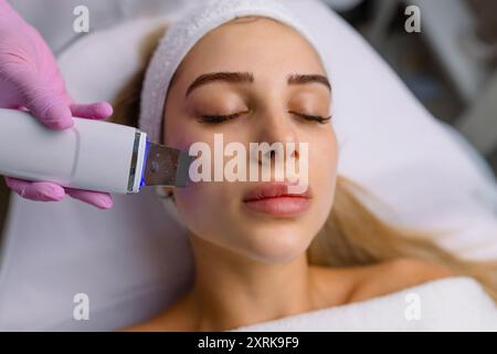 Gesichtsreinigung mit Ultraschall-Scrubber. Frau erhält Ultraschall-Gesichtspeeling und -Reinigung. Kosmetik- und Gesichtspflege. Gesichtsbehandlung Stockfoto