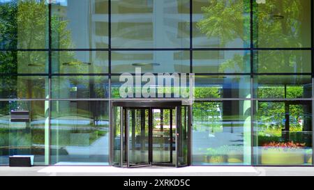 Eingang zum modernen Geschäftsgebäude der Stadt. Moderne urbane Architektur. Die Eingangstür eines Büroblocks, die Gebäude im Glas reflektiert Stockfoto